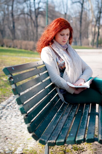 bello libro di lettura della giovane donna della testa di rosso