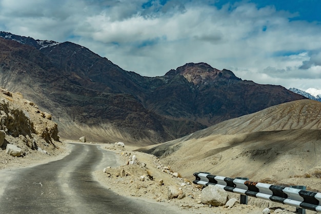 Bello paesaggio della strada sulla strada nella collina con il fondo della montagna della neve, ladakh