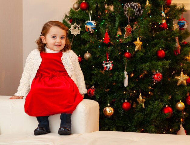 Bello piccolo bambino vicino all'albero di Natale.