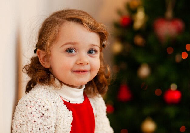 Bello piccolo bambino vicino all'albero di Natale.