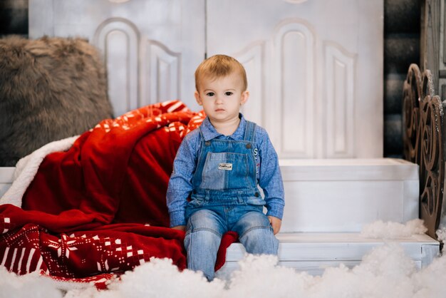 Bello ragazzino sul fondo della decorazione di Natale. Buon Natale e anno nuovo concetto