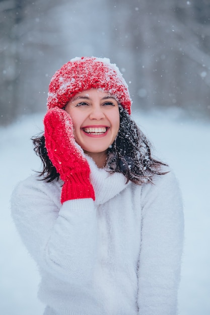 Bello ritratto della donna all'aperto nello spazio della copia della foresta innevata