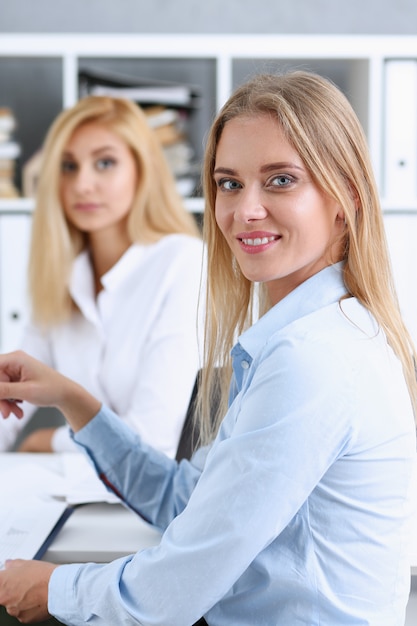 Bello ritratto sorridente della donna di affari sul posto di lavoro