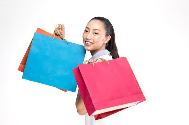 Bello sorriso asiatico attraente della donna e tenere i sacchetti della spesa che sentono così felicità e godono