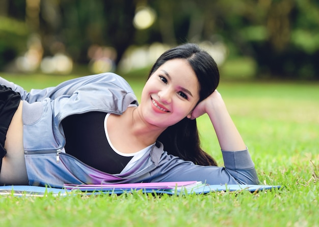 Bello sorriso della donna asiatica di usura di sport nel giardino