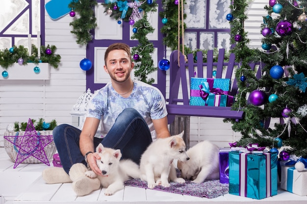 Bello uomo seduto su una terrazza accanto a un Natale con un Ch