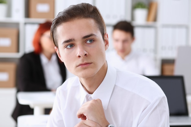 Bello uomo sorridente di affari nel luogo di lavoro