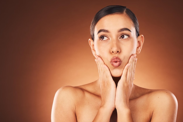 Benessere per la cura della pelle e viso di donna in studio con un trattamento della pelle pulito, sano e naturale Salute bellezza e modella con una routine facciale cosmetica isolata da sfondo marrone con spazio mockup