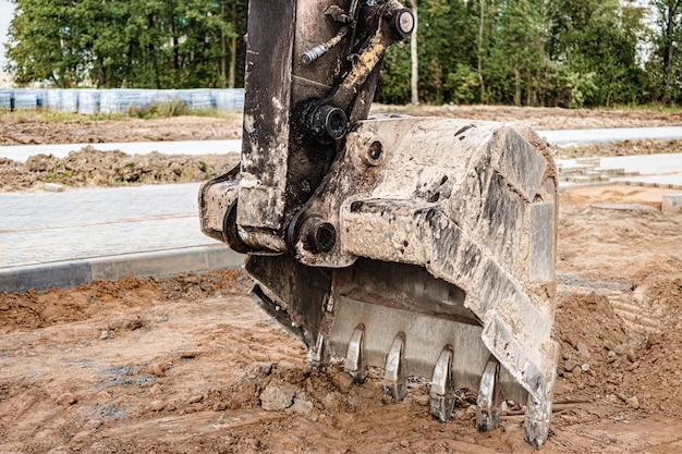 Benna dell'escavatore da vicino. Lavori di scavo in cantiere e costruzione di strade. Macchine da cantiere.