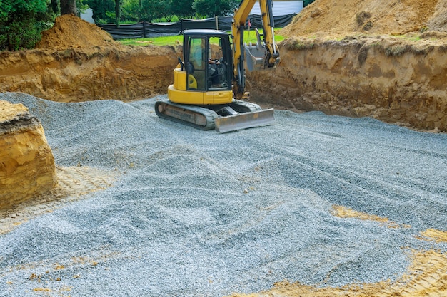 Benna scavatrice di scavatura scavando ghiaia da una fondazione di costruzione