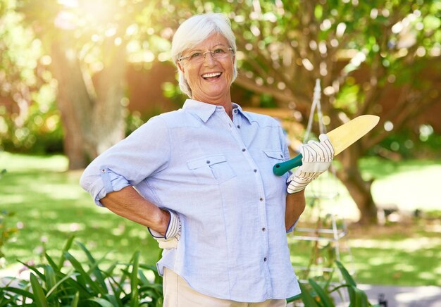 Benvenuti nel mio bellissimo giardino Ritratto di una donna anziana felice che si gode un po' di giardinaggio