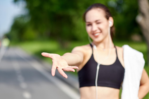 Benvenuto nello sport e nella corsa La donna asiatica in forma attraente ti dà il benvenuto alla pista da corsa con una stretta di mano Dà una mano