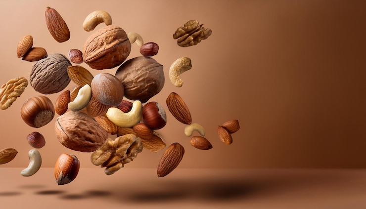 Photo berbagai macam kacang mengambang dengan latar belakang cokelat hangat