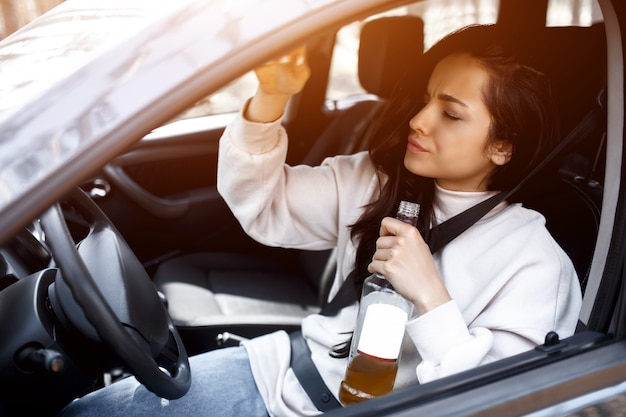 Bere al volante. Una donna ubriaca guida un'auto.