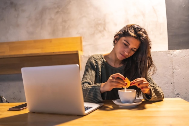 Bere un caffè parlando al telefono e lavorando al computer