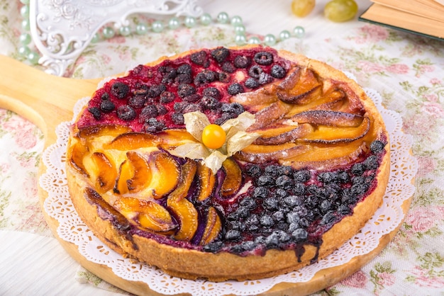 Berry pie, una crostata ripiena di marmellata a base di ribes nero, in vetro forma uno sfondo grigio. Messa a fuoco selettiva, primo piano.