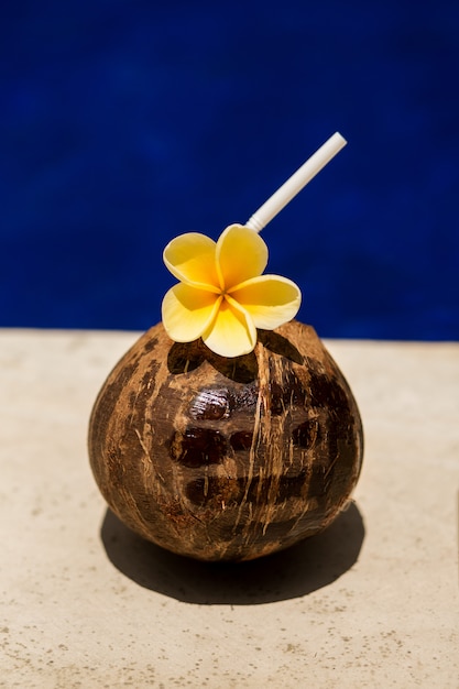 Bevanda al cocco con fiore giallo a bordo piscina