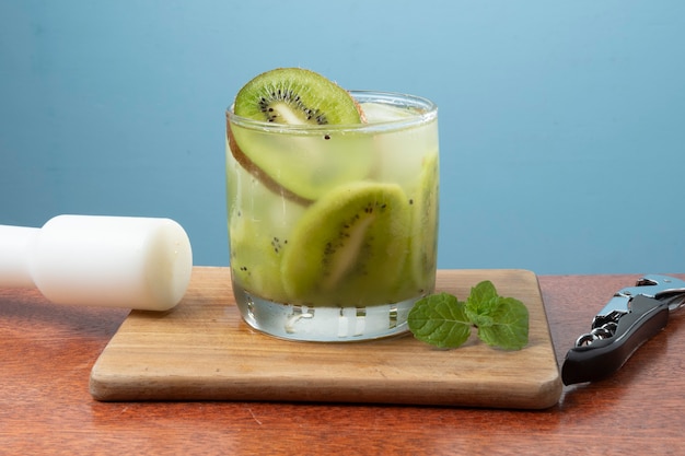 Bevanda alcolica caipirinha a base di kiwi cocktail su una parete blu