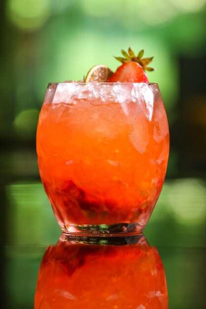 Bevanda alcolica cocktail arancione su sfondo verde sfocato