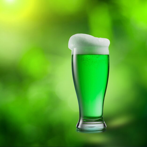 Bevanda alcolica verde naturale della birra su una foglia naturale vaga verde. Felice concetto di giorno di San Patrizio.