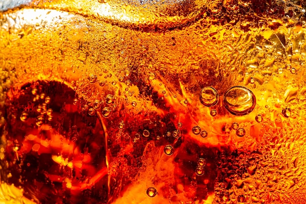 bevanda analcolica macroBicchiere di gustosa cola rinfrescante con cubetti di ghiaccio su sfondo nero closeupCola clo