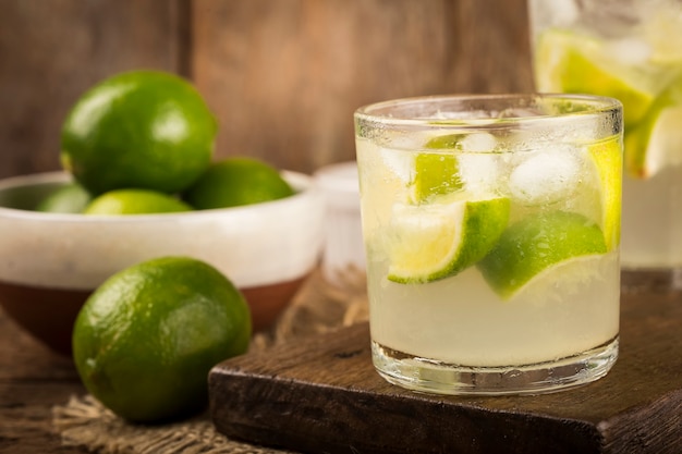 Bevanda brasiliana Caipirinha Cachaa con limone su fondo in legno rustico