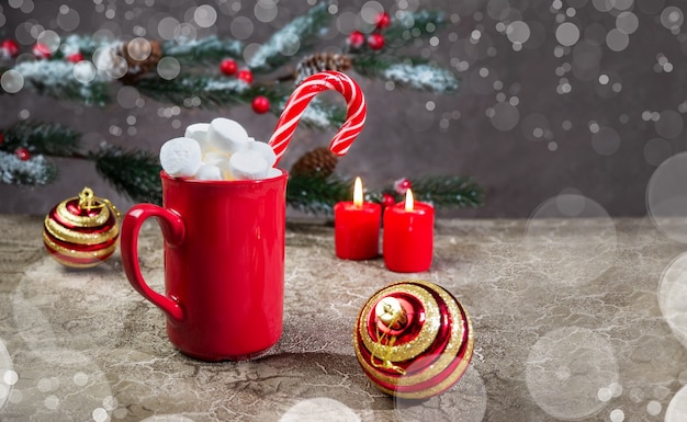 Bevanda calda al cioccolato invernale con marshmallow e caramello in una tazza rossa Tempo di Natale