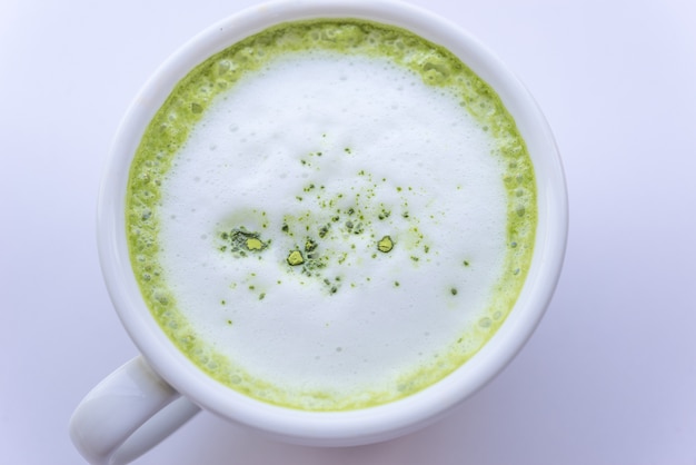 Bevanda calda del latte del tè verde di Matcha in tazza sulla tavola di legno.