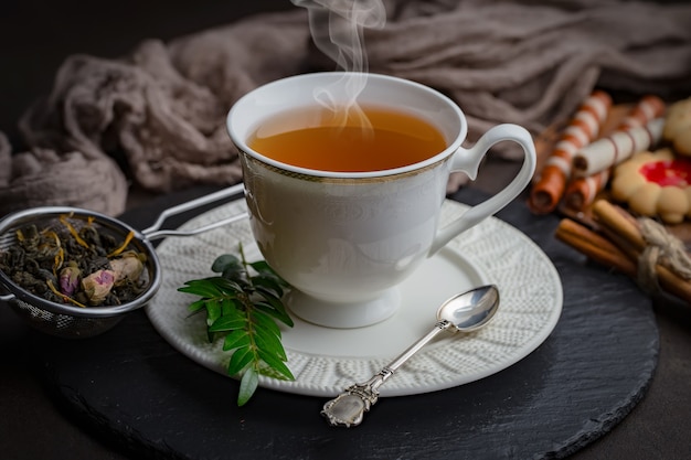 Bevanda calda del tè su vecchio fondo in composizione sulla tavola