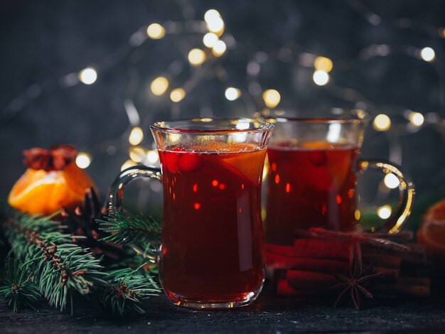 Bevanda calda invernale Vin brulé natalizio in bicchieri con anice, cannella e mandarino