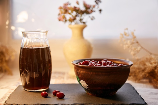 Bevanda calmante salutare naturale con bacche di corniolo Cibo sano autunnale Colori pastello con spazio per la copia Cibo biologico sano Tè vitaminico Decorazioni per l'intimità della casa Tavolo