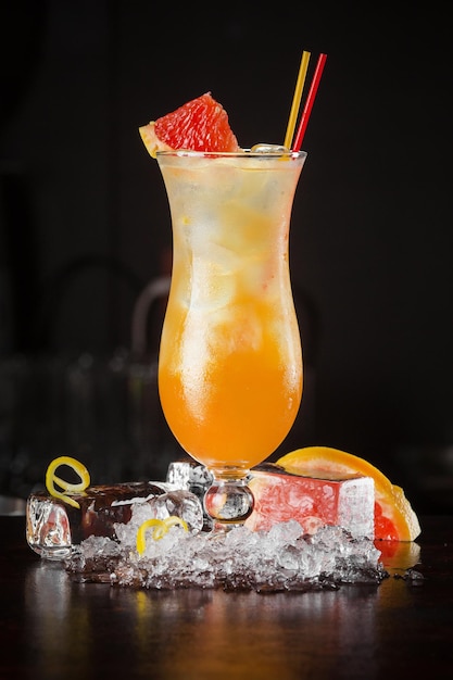 Bevanda cocktail con pompelmo e cubetti di ghiaccio su sfondo nero