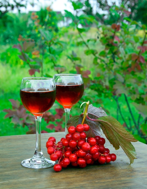 Bevanda di viburno in un bicchiere di vino di viburno su sfondo naturale