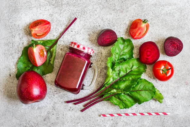 Bevanda disintossicante Di barbabietole, pomodori e mele. Frullati rossi e ingredienti, concetto di disintossicazione.