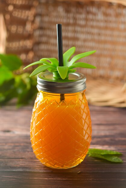 Bevanda estiva, bicchiere di succo d&#39;ananas sul tavolo di legno.