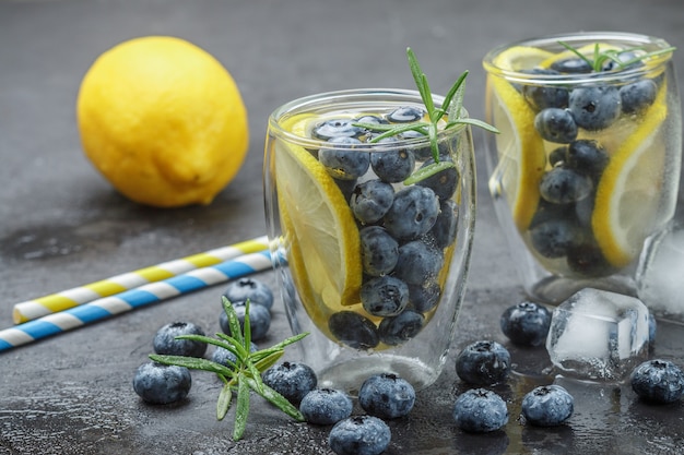 Bevanda estiva rinfrescante con limone, mirtilli, rosmarino e cubetti di ghiaccio. Detox, limonata, cocktail. Messa a fuoco selettiva