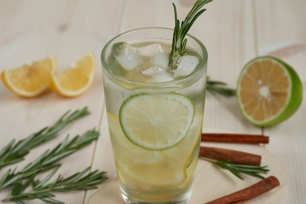 Bevanda fresca con ghiaccio, limone, lime su uno sfondo di legno