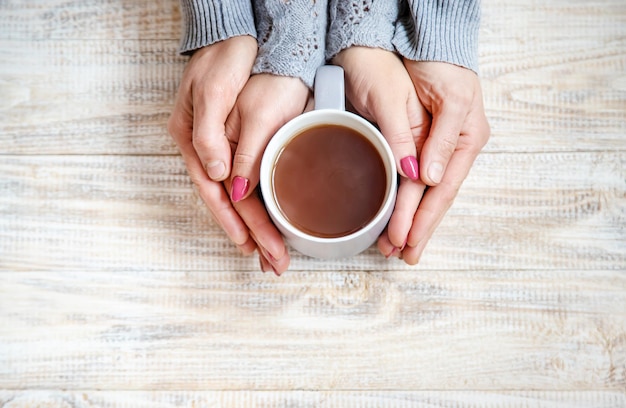 Bevanda in tazza per la colazione nelle mani degli innamorati Messa a fuoco selettiva