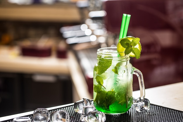 Bevanda Mojito o limonata con foglie di menta sul bancone del bar.