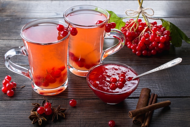 Bevanda piccante calda con viburno in tazze di vetro con bacche fresche di viburno su un tavolo da cucina dsrk.