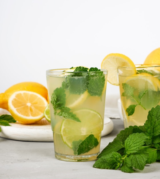 Bevanda rinfrescante estiva limonata con limoni, foglie di menta, lime in un bicchiere