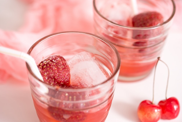 Bevanda rossa con ghiaccio, foglie di menta e fragola. Strumenti per la preparazione di cocktail