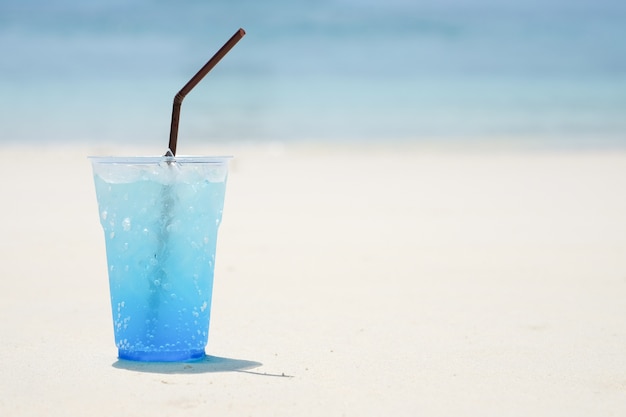 Bevanda tropicale della soda blu dell&#39;Hawai sul chiaro cielo sopra la spiaggia del mare. Le vacanze estive rilassano lo sfondo con il co