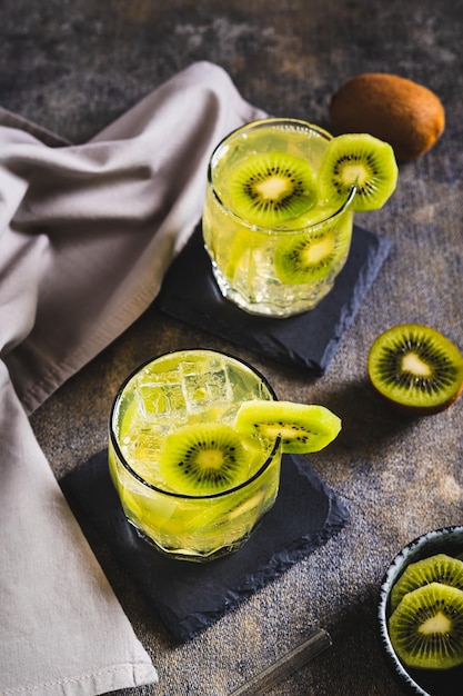 Bevanda tropicale rinfrescante mojito con kiwi in bicchieri sul tavolo vista verticale