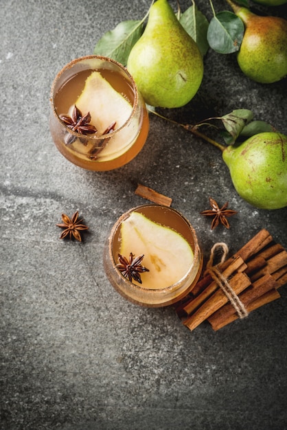 Bevande autunnali Vin brulè. Tradizionale cocktail autunnale speziato con sciroppo di pera, sidro e cioccolato, con cannella, anice, zucchero di canna. Sul tavolo di pietra nera. vista dall'alto di copyspace