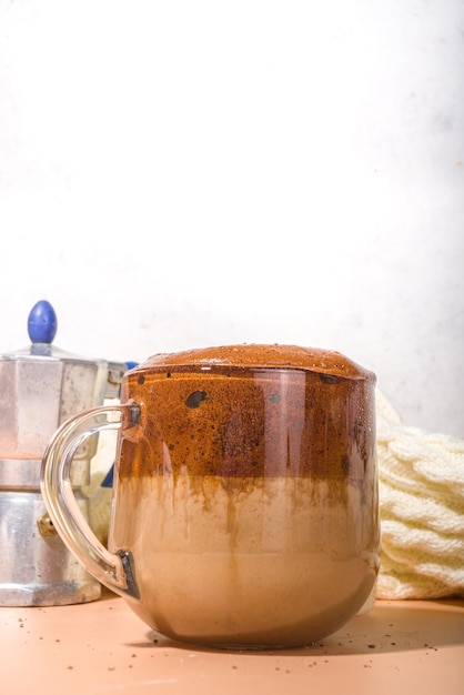 Bevande calde autunnali. Latte speziato fatto in casa con crema di zucca montata al caffè Dalgona, con caffè istantaneo e spezie di zucca