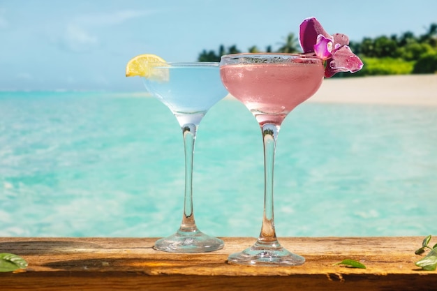 Bevande estive Cocktail alcolici blu e rosa sulla spiaggia tropicale