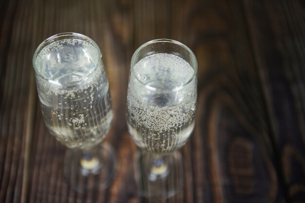 Bevande per vacanze in vetro prosecco come feste a tema e feste con bicchieri di champagne per le vacanze invernali decorate a Natale sul tavolo di legno