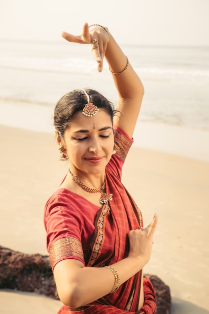 Bharatanatyam di danza classica indiana eseguita da una bella donna in abiti tradizionali al tramonto