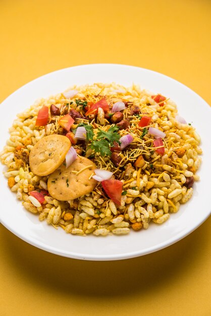 Bhel Puri è uno spuntino salato o un prodotto Chaat dall'India. È fatto di riso soffiato, verdure e salsa di tamarindo piccante. Popolare cibo indiano lungo la strada?